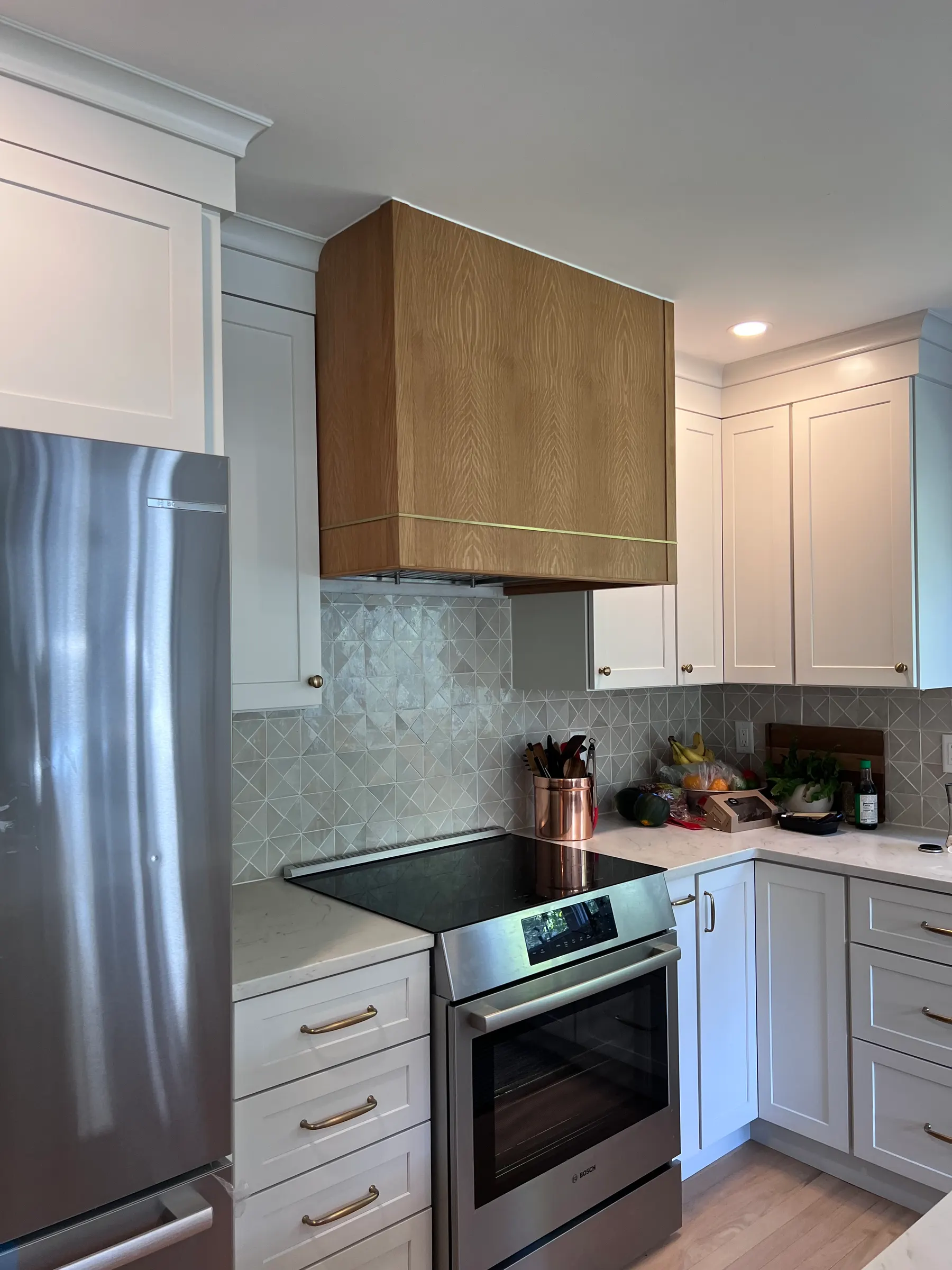 Two-tone kitchen with white perimeter cabinets and an oak island